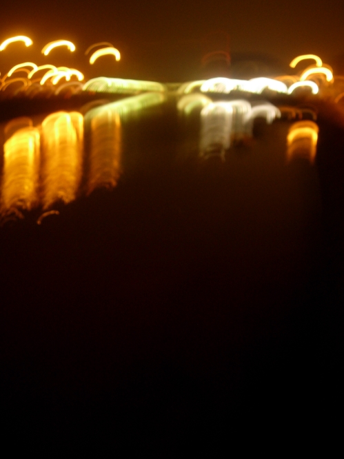 Desde Olabeaga, hacia el puente Euskalduna, por la noche, muevo la c�mara para capturar una foto donde las luces, de diferentes colores, reflejadas sobre la r�a, dibujan la ciudad con curvas y arcos de luz.