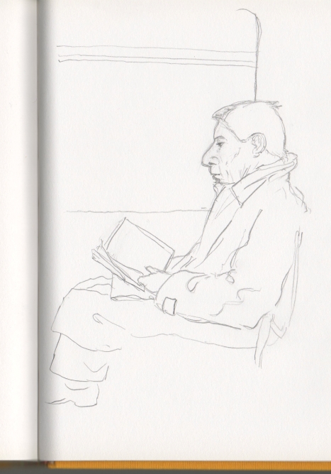Un hombre absorto en la lectura, abigado en su gabardina.