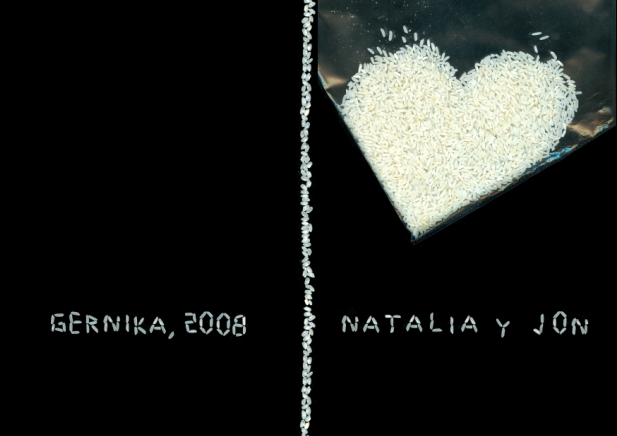Sobre fondo negro, una bolsita transparente forma en su v�rtice un coraz�n de arroz; debajo, los nombres de los novios, Natalia y Jon, escritos con letras formadas por granos de arroz.